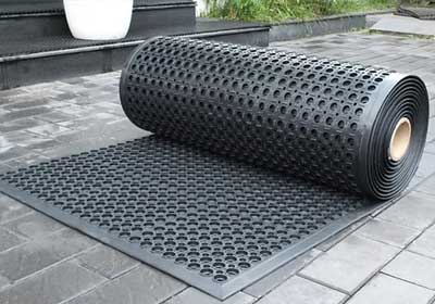 Close-up of heavy-duty non-slip rubber matting on a wet industrial floor